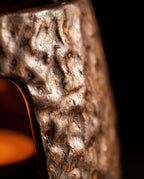 Macro of the hand-glazed bronze ceramic craft texture, warm glow within