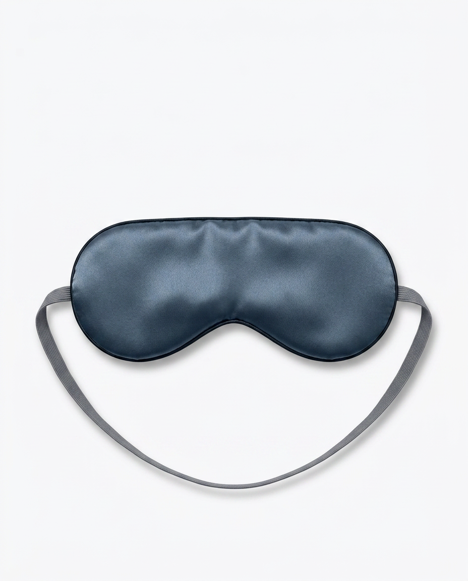 Navy blue silk sleeping eye mask with grey strap, packshot on white