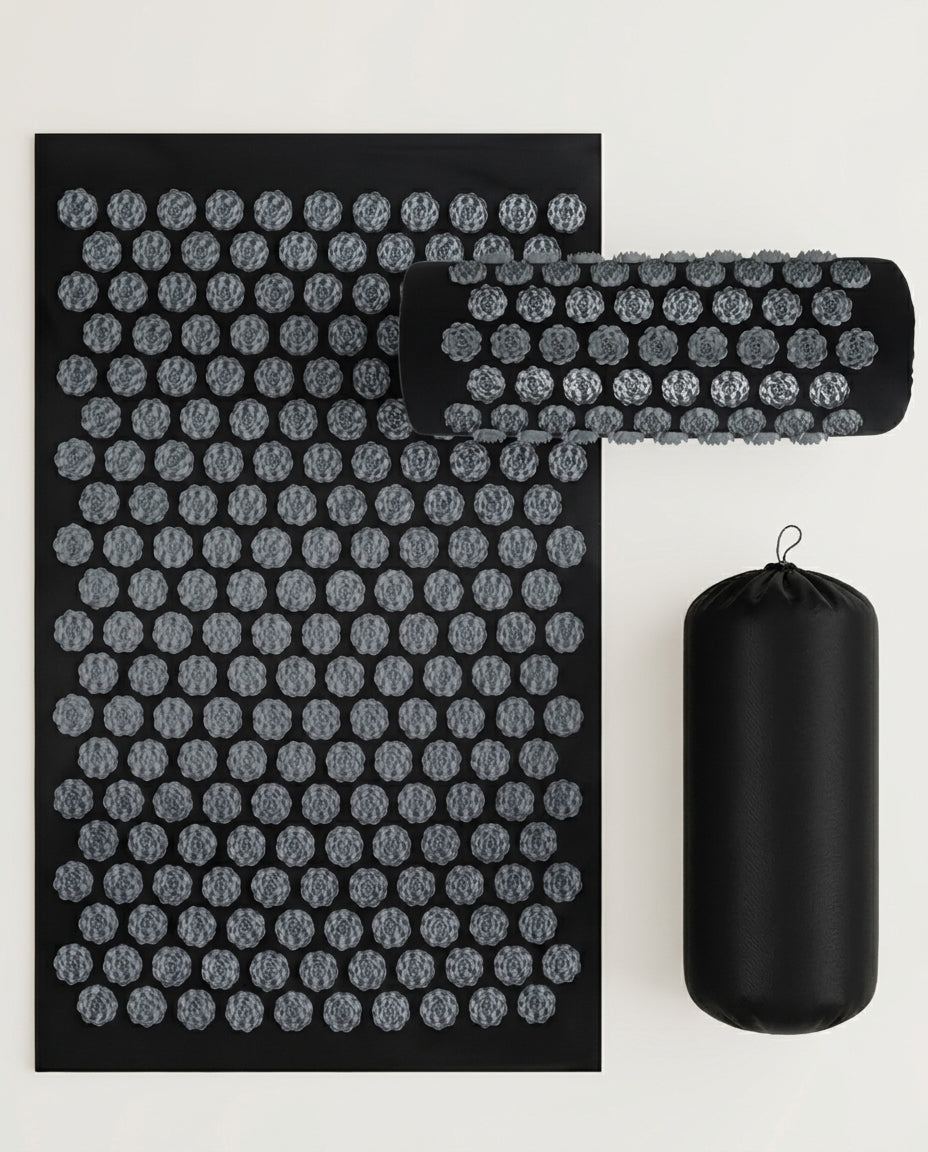 Grey acupressure mat with rolled pillow and carry bag on white