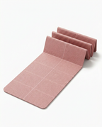 Dusty pink foldable yoga mat partly unfolded in accordion panels